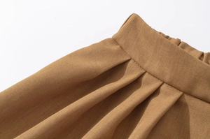 Macro view of khaki twill high-waisted shorts with refined parallel pleated details