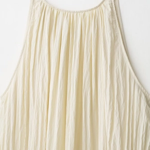 Chic cream sleeveless pleated dress for women with elegant draped texture and halter neck