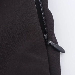 Detailed close-up of a high-quality invisible zipper on a black textured summer dress