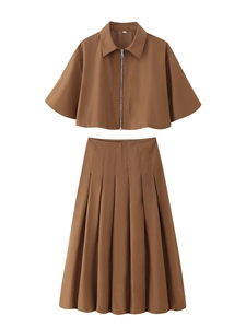 Détail d'un ensemble marron deux pièces avec veste courte zippée et jupe plissée mi-longue