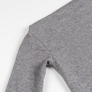 Detail of the high-quality grey knit fabric texture and seam stitching on the shoulder