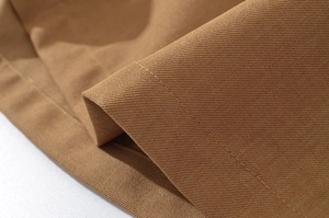 Close-up of khaki twill cotton fabric texture and precise stitching on casual jacket set