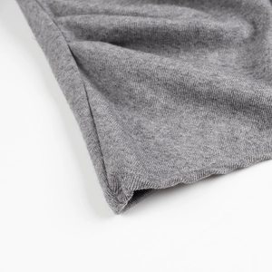 Close-up of grey knitted fabric texture and ribbed cuff detail on women sweater