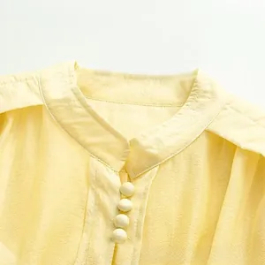 Détail du col montant élégant avec boutons recouverts de tissu et matière texturée