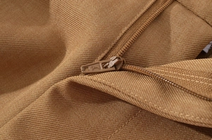 Detail of high-density brown twill jacket with a logo zipper and durable texture