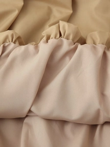 Gros plan du tissu tissé kaki montrant les volants plissés et les détails de couture