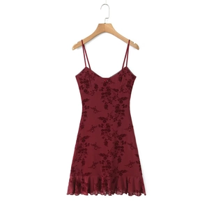 Detail of burgundy floral flocked camisole dress with 3D rose accent and ruffled hem