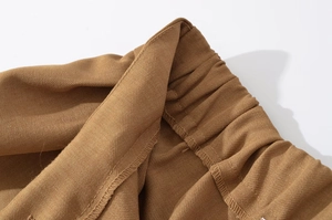 Detailed close-up of the tan twill fabric jacket featuring a sturdy elasticated waistband