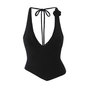Detail of black knit halter top showing 3D flower accent and intricate V-neck crochet