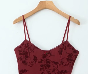 Detailed view of burgundy mesh fabric with floral flocking and red rose lace neckline