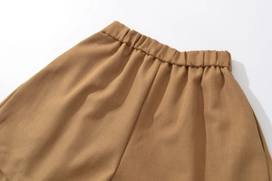 Detailed macro view of the elastic waistband on tan cotton twill casual shorts