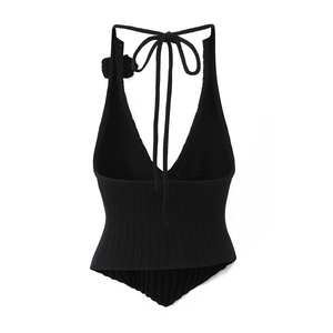 Detail view of knitted halter top featuring floral accent and ribbed fabric texture
