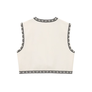 Gros plan de la broderie florale noire au dos d'un gilet sans manches beige