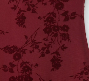 Detailed macro view of vintage dark red floral flocking on semi-transparent mesh fabric