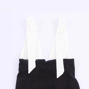 Elegant black and white halter neck top with deep V-neck and decorative shoulder bows