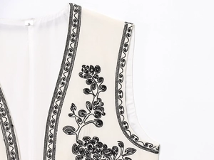 Détail de broderie florale sur gilet sans manches crème avec étiquette de taille S