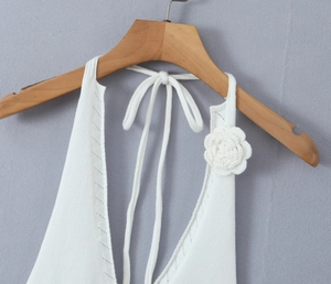 Detailed view of the white knitted halter neck top with handmade 3D rose applique