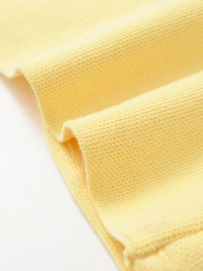 Close-up detail of soft light yellow knit fabric showing fine texture and smooth weave