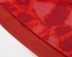 Close-up of French vintage floral chiffon fabric with refined stitching and red floral patterns