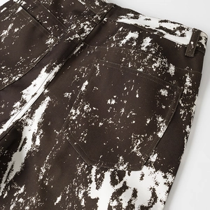 Dettaglio della vita e tasche posteriori di pantaloni in twill marrone con stampa vernice