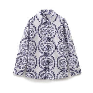 Detail of purple floral embroidery on white long-sleeve cotton shirt with buttons