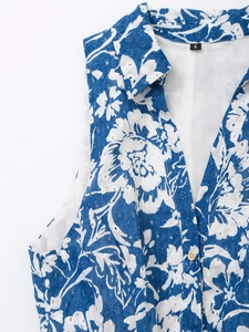 Détail d'une robe d'été à imprimé floral bleu avec broderie anglaise et boutons bois