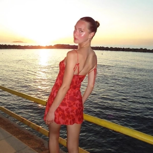 French vintage red floral print mini dress with tie straps in a beach sunset setting