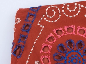 Macro di gonna estiva rossa con intricati ricami multicolori e dettagli traforati in pizzo