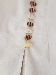 Chic beige linen vest for women featuring unique tortoiseshell style buttons and natural texture
