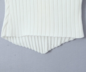 Detailed view of white ribbed knit fabric featuring an irregular asymmetrical hem design