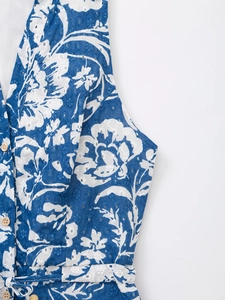 Gros plan sur les broderies florales bleues et les dentelles ajourées de la robe d'été