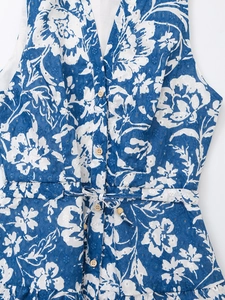 Détail de la broderie col en V et fermeture à boutons sur robe d'été à fleurs bleues