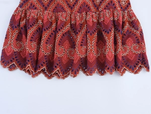 Dettaglio gonna boho rosso ruggine con ricamo traforato complesso e bordo a balze smerlato
