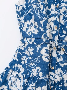 Détail d'une robe en broderie anglaise à fleurs bleues avec boutons en bois