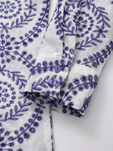 White casual long-sleeved shirt featuring purple geometric floral embroidery and buttoned cuffs
