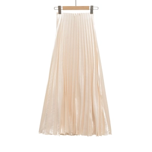 Detailed view of champagne satin pleated skirt with glossy finish and fine vertical pleats