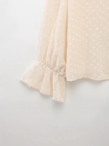 Elegant apricot Swiss dot sheer blouse with ruffled cuffs and feminine textured fabric