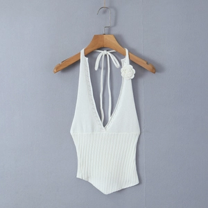 White knit halter top with deep V-neck, floral accent, and asymmetrical pointed hemline