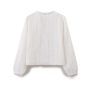 Close-up of white V-neck blouse featuring intricate eyelet embroidery and lantern sleeves