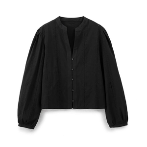 Detailed view of the hollow-out floral embroidery and buttoned front on a black shirt
