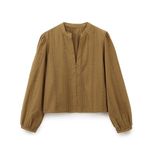 Close-up of intricate hollow embroidery and buttons on mustard yellow long sleeve shirt