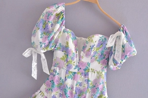 Detail of floral puff sleeves with white lace bow ties on a vintage summer dress