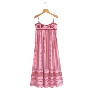Détail de la broderie complexe au crochet rouge foncé sur une robe d'été rose imprimée