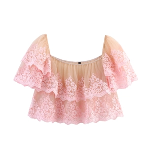 Detailed close-up of pink layered mesh ruffles and floral lace embroidery on crop top
