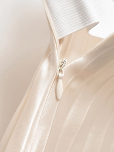 Detailed macro view of invisible teardrop zipper on elegant white satin high waist skirt