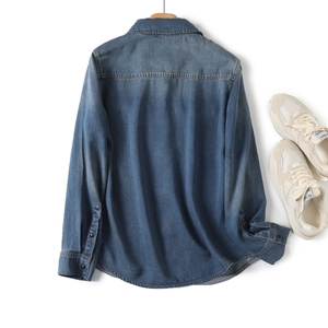 Back view of classic mid-blue denim shirt with back pleat and soft washed texture