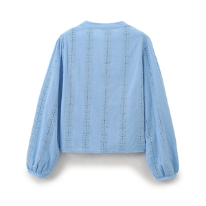 Detail of light blue shirt featuring intricate vertical eyelet embroidery and soft texture