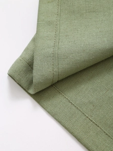 Vue macro du tissu vert en coton et lin avec détails de couture à double aiguille