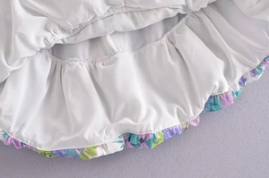 Detailed close-up of French floral dress hem featuring ruffled edges and inner lining