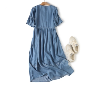 Close-up of white floral embroidery details on the sleeves of this blue denim midi dress